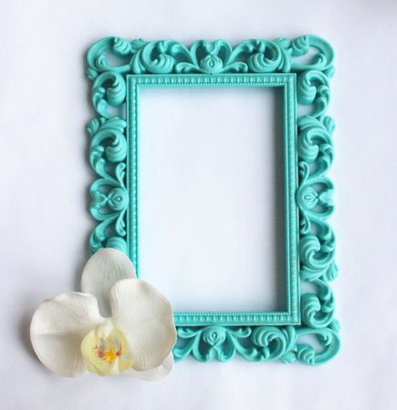 Turquoise vintage frame with orchid flower on white background.の写真素材