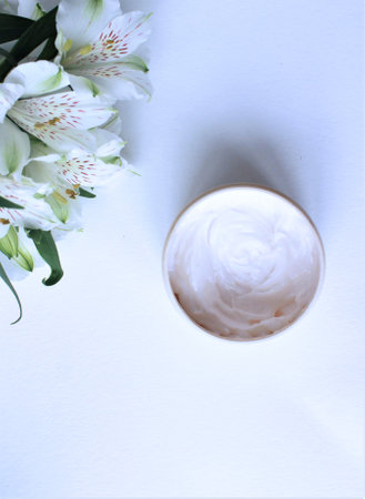 cosmetic cream with white flowers on a white background, top viewの写真素材