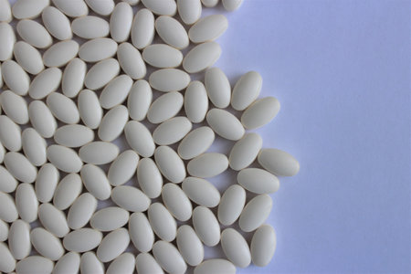 White pills on a white background. Close up. Top view.