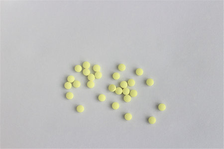 Yellow pills on a white background. Top view. Copy space.