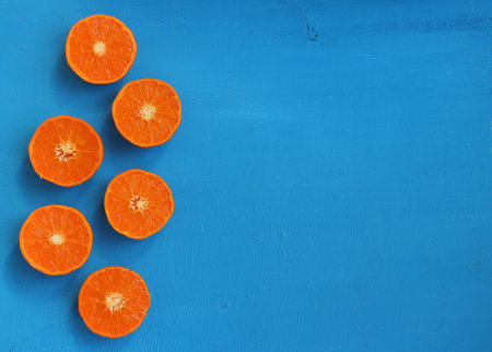 Ripe tangerines on a blue wooden background. Top view.の写真素材