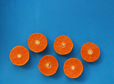 Slices of orange on a blue wooden background.の写真素材