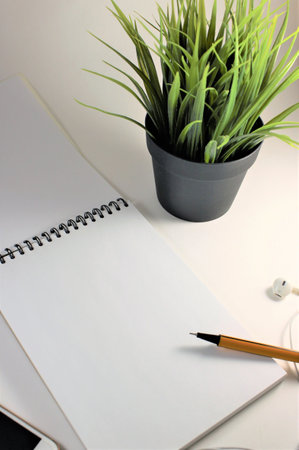 Notebook with pencil on white table. Copy space