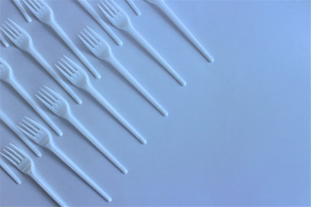 Disposable plastic forks on a blue background