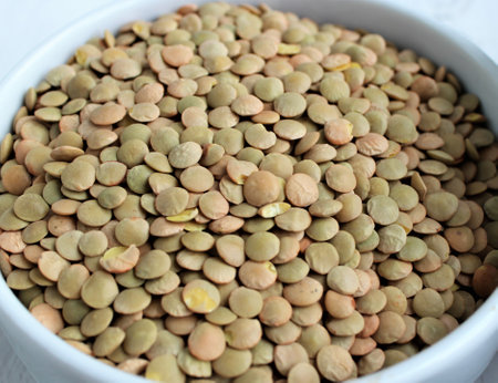 Lentils in a bowl on a white background, close up