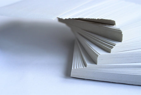 A stack of white paper sheets on a white background close-upの写真素材