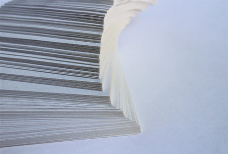Close up of a stack of magazines on a white background with copy spaceの写真素材