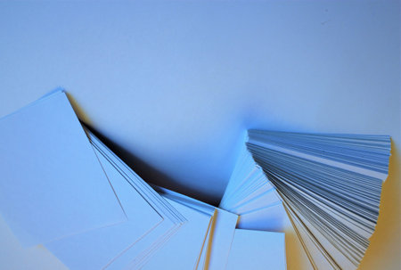 Pile of empty paper sheets on blue background, closeup of photo
