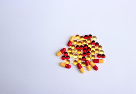 Pills and capsules on white background. Focus on foreground, soft bokeh.
