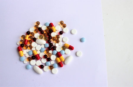 Colorful pills and capsules on white background. Focus on foreground, soft bokeh.