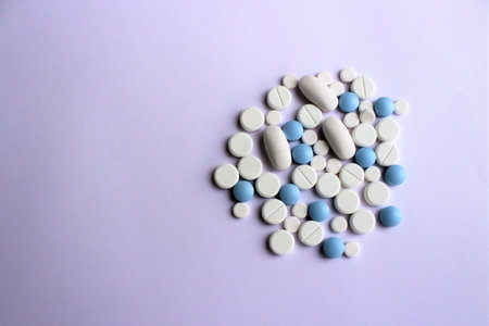 White and blue pills on purple background. Top view. Copy space.の写真素材