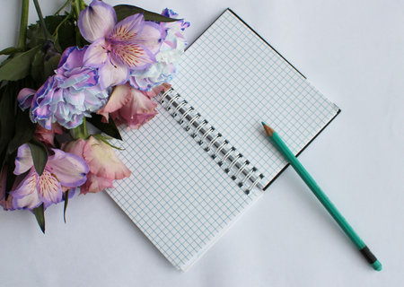 Bouquet of flowers and a notebook on a white background.の写真素材