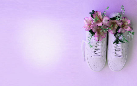 White sneakers with flowers on a purple background. Place for text.の写真素材