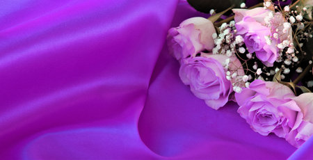 Wedding bouquet of pink roses on purple satin backgroundの写真素材