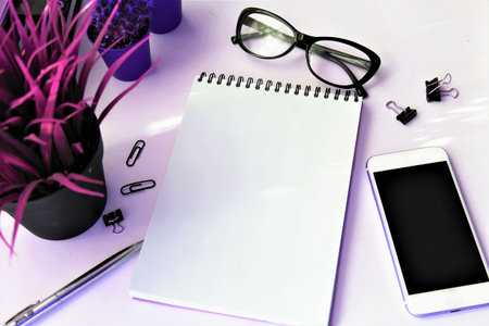 Notebook, pen, glasses and mobile phone on white background.の写真素材