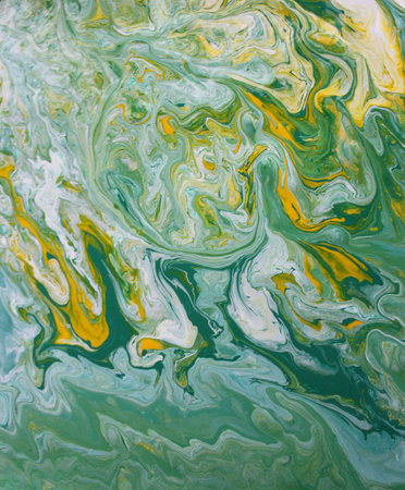 abstract background of colored marbling paint in green and yellow tones