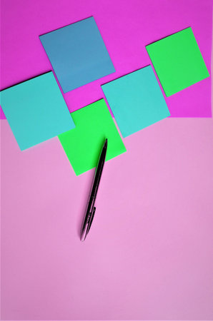 Colorful sticky notes and pen on pink background. Top view.の写真素材