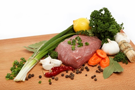 raw meat, vegetables and spices isolated on a wooden table の写真素材