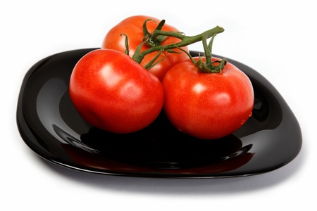 Fresh tomatoes on a plate, isolated on a white background の写真素材