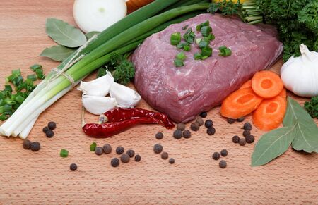 raw meat, vegetables and spices isolated on a wooden table の写真素材