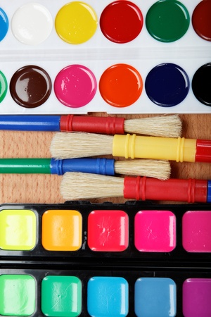 Paint, palette and brushes on a wooden table の写真素材