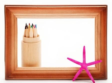 Colored pencils in a wooden frame on a white background.