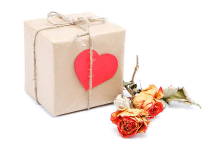 Vintage gift with a red valentine heart and a rose isolated on white background.の写真素材