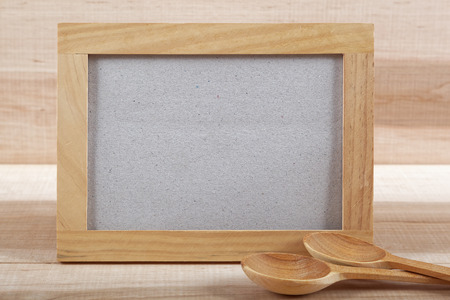 Kitchen utensils and wooden frame on a wooden board.の写真素材