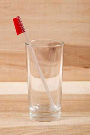 Toothbrush in a glass on a wooden board.の写真素材