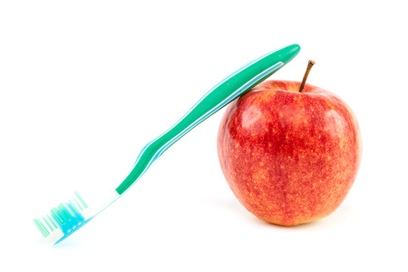 Toothbrush and fresh red apple isolated on white background.の写真素材