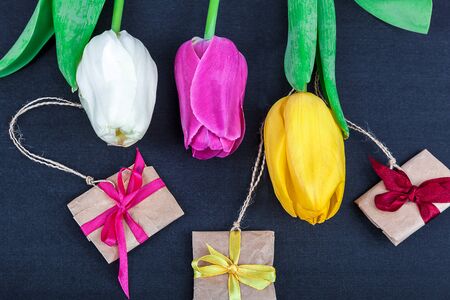 Tulip Flowers and gifts on a black background.