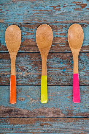 Colored kitchen spoons on a wooden background. Accessories for cooking.の写真素材