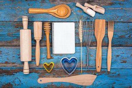 Set kitchen utensils and a notebook for recipes on a wooden background.の写真素材