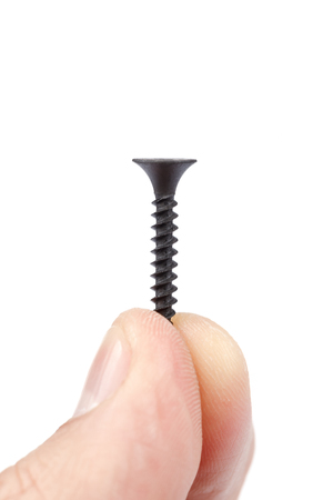 A metal self-tapping screw in the hand, isolated on a white background.の写真素材