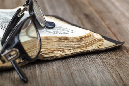 Ancient holy book of a wooden cross on a cord on a wooden background.の写真素材