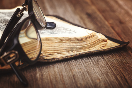 Ancient holy book of a wooden cross on a cord on a wooden background.の写真素材