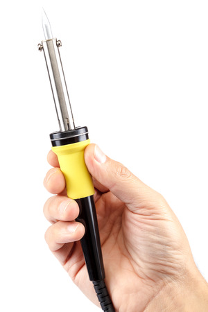 A soldering iron in a hand isolated on a white background.の写真素材