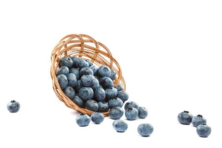 Fresh blueberries in a wicker basket isolated on a white background.の写真素材