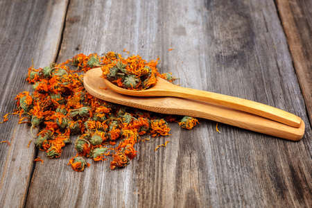 Dried calendula flowers on wooden background. Medicinal plants.の写真素材