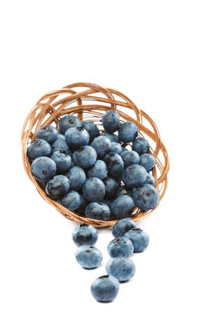 Fresh blueberries in a wicker basket isolated on a white background.の写真素材