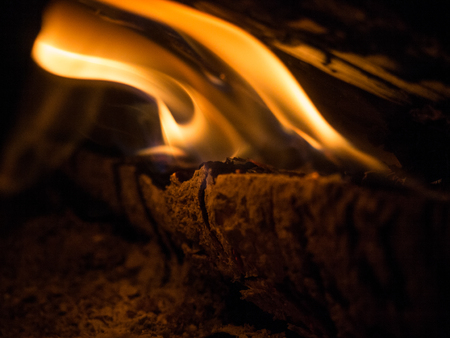 Burning wood and flames in a fireplace on a black background