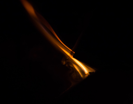 Burning wood and flames in a fireplace on a black background