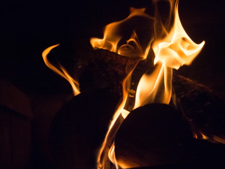 Burning wood and flames in a fireplace on a black backgroundの写真素材