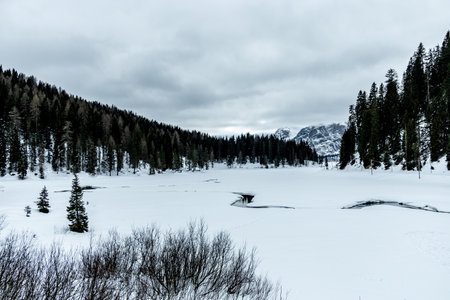 Hike around the snow-covered lake at the gates of the Three Peaks Nature Park - Italyの写真素材