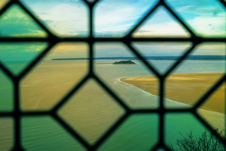 A view through a window at the famous Mont St Michel abbey in France.の写真素材