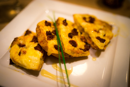 A chorizo and honey pizza with herbs.