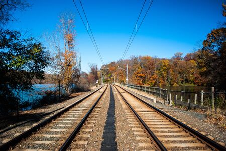 Photograph of double track railroad lines with vanishing perspective taken in autums with overhead catenary lines.の写真素材
