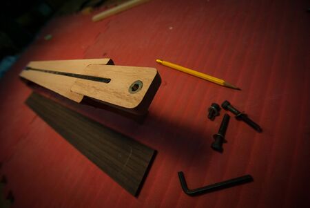 Photograph of the fretboard and neck of guitar with associated tools utilized to attach the neck to the guitar body の写真素材