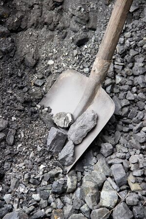 Old shovel stuck in the coal in the hole.の写真素材