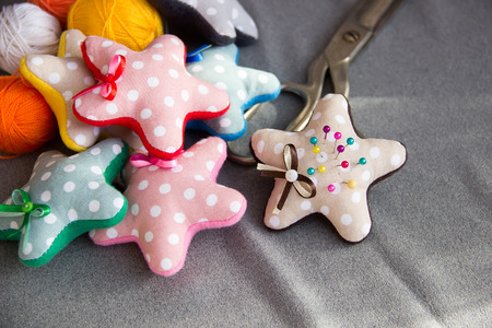 Textile stars with needles, scissors and threads.